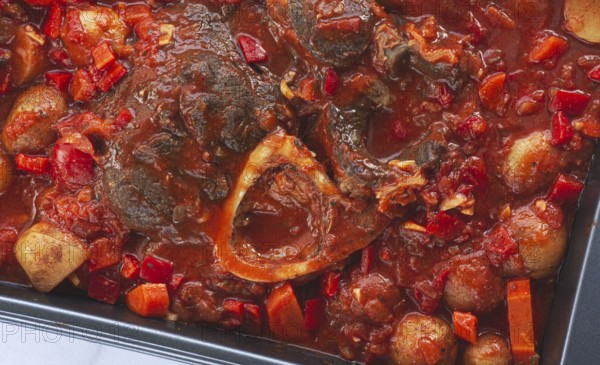 Ossobuco stew with vegetables, knuckle on the bone with new potatoes, in tomato sauce, homemade,