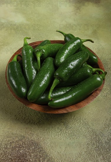 Fresh padron pepper, raw, in a wooden bowl, on the table, there are no people