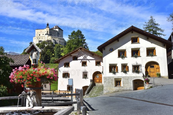 Village fountain in Tarasp, municipality of Scuol, in the background Tarasp Castle in the Lower