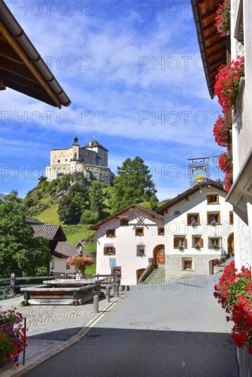 Village fountain in Tarasp, municipality of Scuol, in the background Tarasp Castle in the Lower