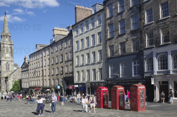 Lively street view with historic buildings and striking red telephone boxes in daylight, Royal