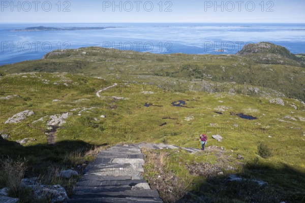 Woman with backpack climbing up stone stairs, Sherpat stairs or Midsund stairs or Midsundtrappene,