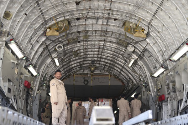 Members of the Qatari Air Force unload humanitarian aid supplies from a transport aircraft at