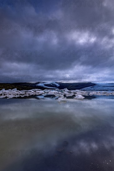 Ice floes, lake, shore, stones, glacier tongue behind, glacier, glacier lagoon, cloudy, summer,