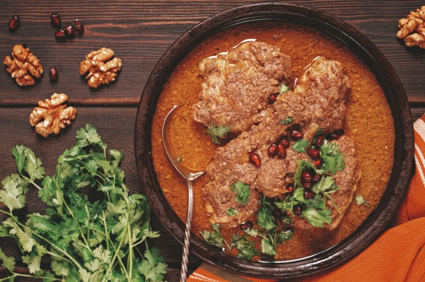 Fesenjan, an Iranian dish, stewed chicken, in walnut-pomegranate sauce, in an earthen pan,