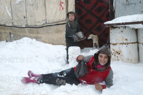 Displaced Syrian families and children living in refugee camps during harsh winter conditions,