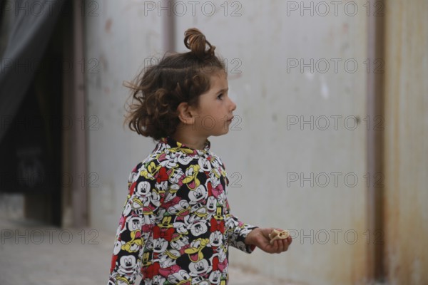 A Syrian refugee child photographed in a camp, reflecting the harsh living conditions of displaced