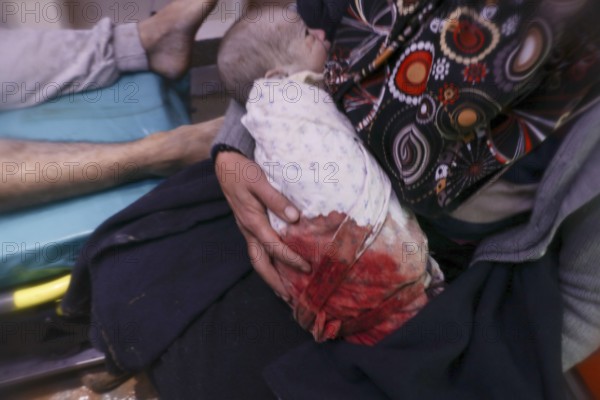 A frightened mother carries her infant after he was pulled from the rubble of a deadly earthquake