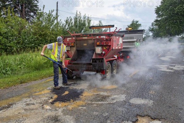 Glendora, Michigan - A worker for the Berrien County Road Department patches potholes on Wagner