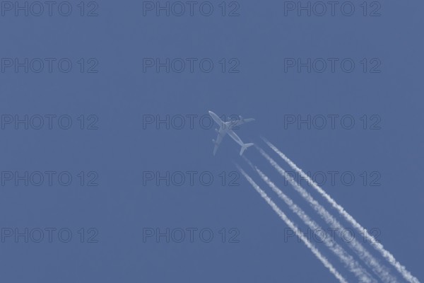 Airbus A340-300 jet aircraft of Lufthansa airlines in flight in a blue sky with vapour trails or