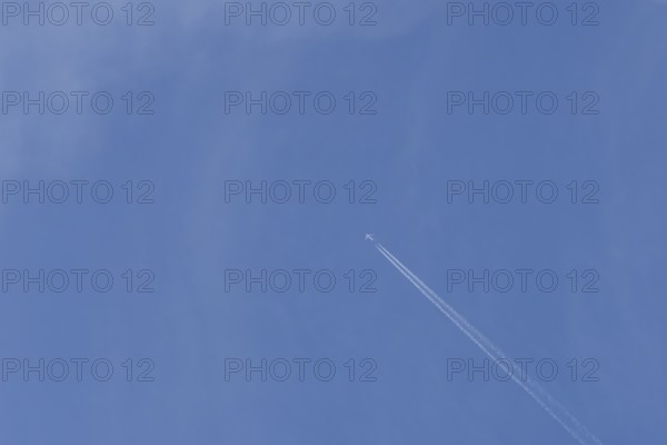 Boeing 737 jet passenger aircraft of Norweign Air with a vapour trial or contrail behind flying in