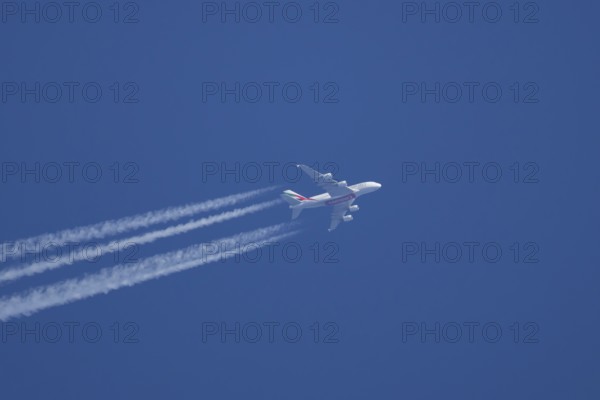 Airbus A380 jet passenger aircraft of Emirates airlines flying with vapour trails or contrails