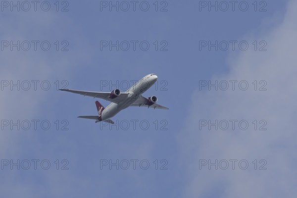 Boeing 787 Dreamliner jet passenger aircraft of Virgin Atlantic airlines in flight in a blue sky,