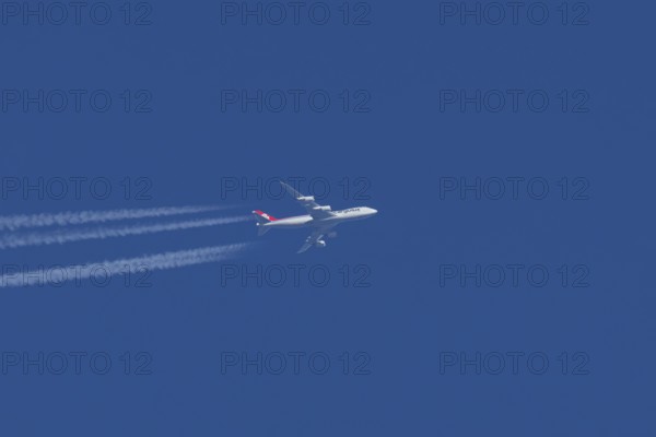 Boeing 747 jumbo jet cargo aircraft of Cargolux airlines with a vapour trail or contrail flying in