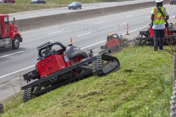 Harper Woods, Michigan - Remote-control mowers are cutting the grass and weeds along Interstate 94