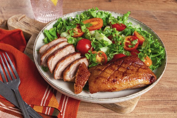 Delicious grilled duck breast served with fresh garden salad and cherry tomatoes at a rustic dining