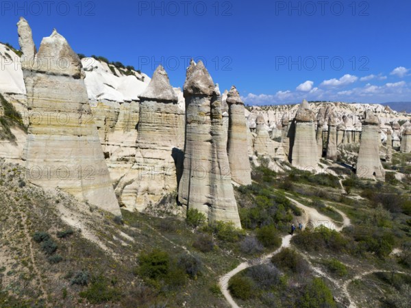 Impressive rock formations under a blue sky in Cappadocia with hiking trails, aerial view, Love