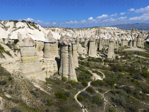Panorama of imposing rocks and cliffs with a winding path in sunny surroundings, aerial view,