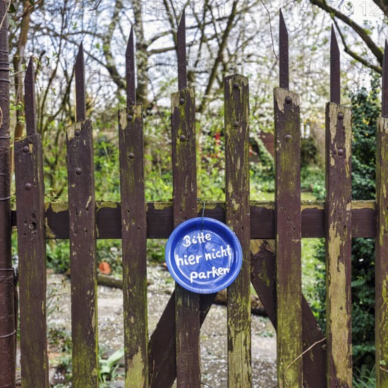 Funny sign at the old garden gate, blue plate with inscription, Please do not park here, Hanover,