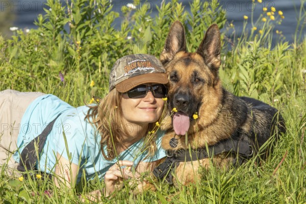 Woman and her German Shepherd lying in the grass, Woman and her German Shepherd lying in the grass,