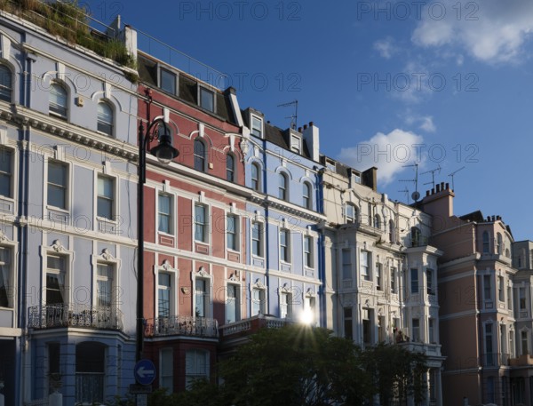 Terraced houses, townhouses with different, colourfully painted facades under a blue sky,