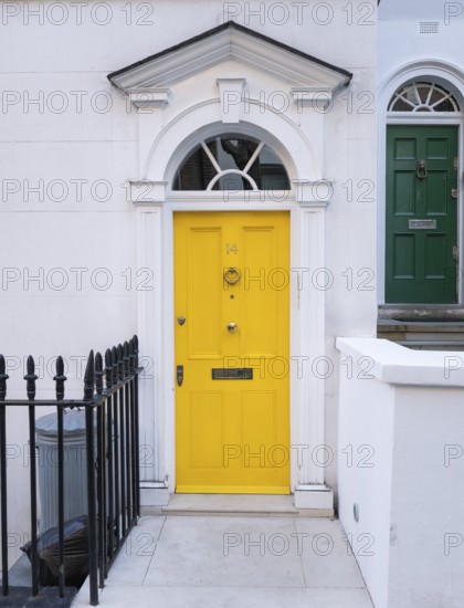Bright yellow front door with neoclassical triangular pediment, Palladian-style entrance, white