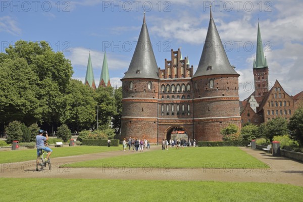 Historic Holsten Gate and pedestrians, tourists, photograph, St. Mary's Church, Lübeck St. Peter's