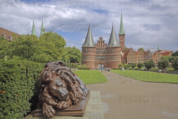 Sleeping lion figure at the historic Holstentor and St. Peter's church tower in Lübeck, Brick