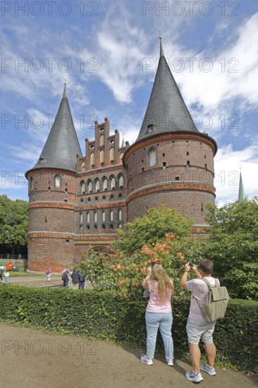 Historic Holsten Gate and tourists taking photos, Brick Gothic, Brick building, City gate,