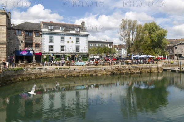 People sitting outside The Three Crowns pub quayside harbour, The Barbican, Plymouth, Devon,