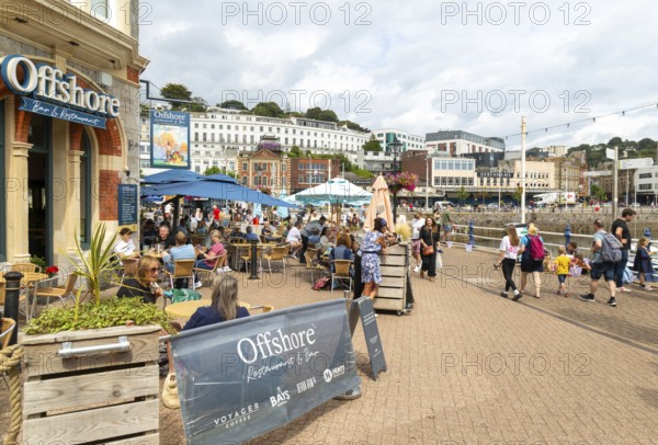 Offshore bar and restaurant, people walking on quayside, Vaughan Parade, Torquay, Devon, England,