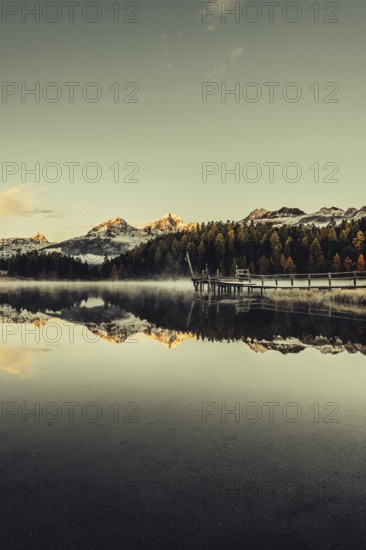 Lake Staz near Sankt Moritz in the Engadin in Switzerland. Morning atmosphere with fog in autumn.
