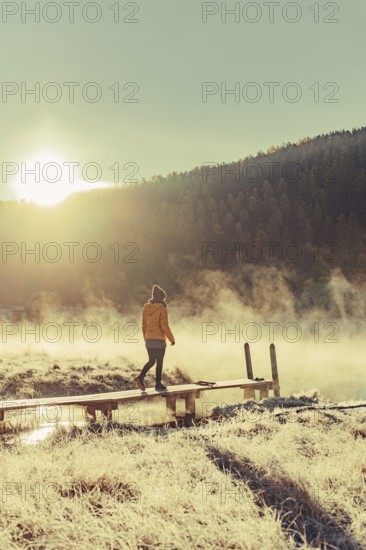 Young woman at Lake Staz near Sankt Moritz in the Engadine in Switzerland. Morning atmosphere with
