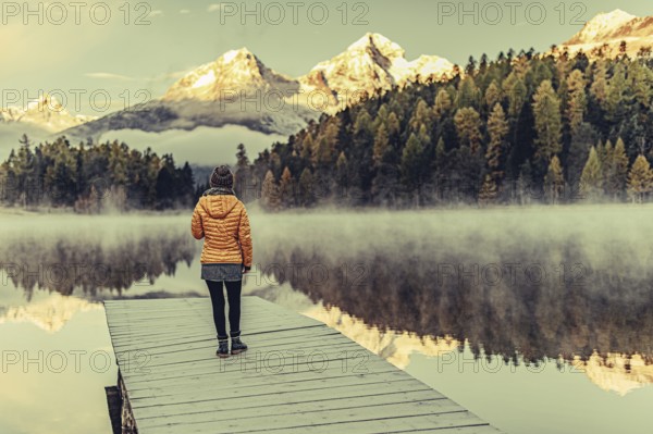 Young woman at Lake Staz near Sankt Moritz in the Engadine in Switzerland. Morning atmosphere with