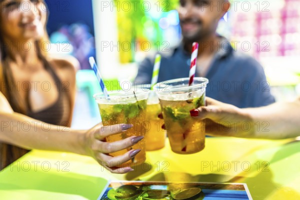 Friends enjoying refreshing mojito cocktails at a vibrant beach bar, celebrating summer with a