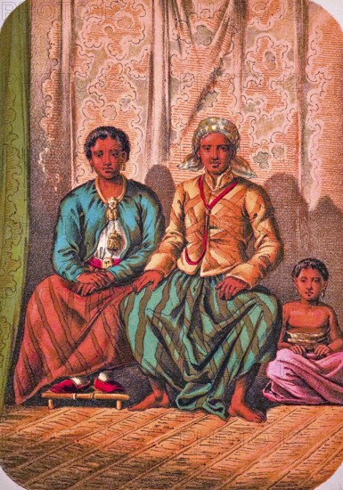 Seated Javanese family with father, mother and child, traditional clothing, headscarf, jacket, long