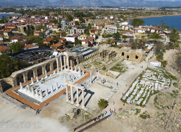 Ancient ruins next to a town overlooking the sea. Historical and scenic scenery, aerial view,