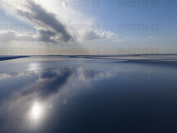 Fascinating lake landscape with calm water that reflects the sky and clouds, radiates peace and