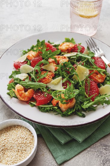 Fresh shrimp salad with arugula, grapefruit, and parmesan served in a bowl