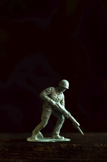 A small soldier figure stands ready with a rifle, capturing the essence of military readiness and