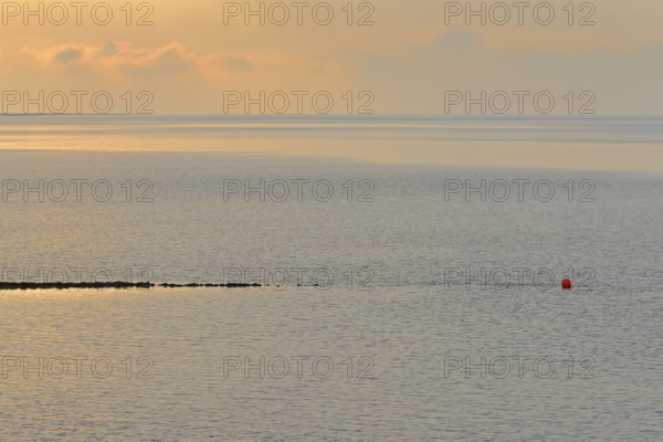Evening mood at the Wadden Sea, stone groyne with red buoy, North Sea, Norddeich, Lower Saxony,