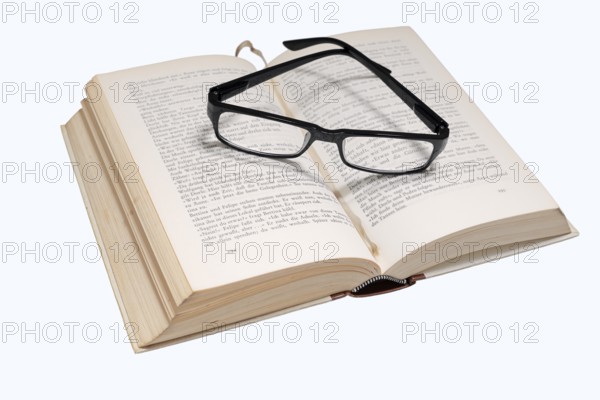 Reading glasses and book on a white background