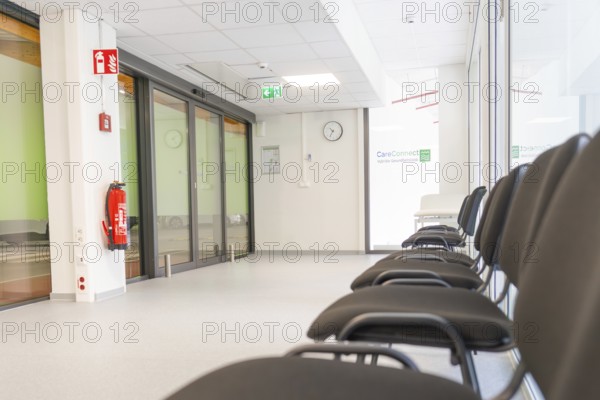 Modern corridor with chairs and escape signs in bright surroundings, Care Connect, vaccination