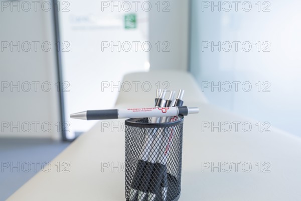 Pen holder with pens on a desk in a modern office, Care Connect, vaccination kiosk for refugees,