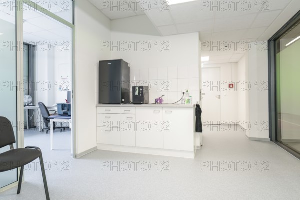 Modern kitchenette in the office with white cupboards and appliances, Care Connect, vaccination