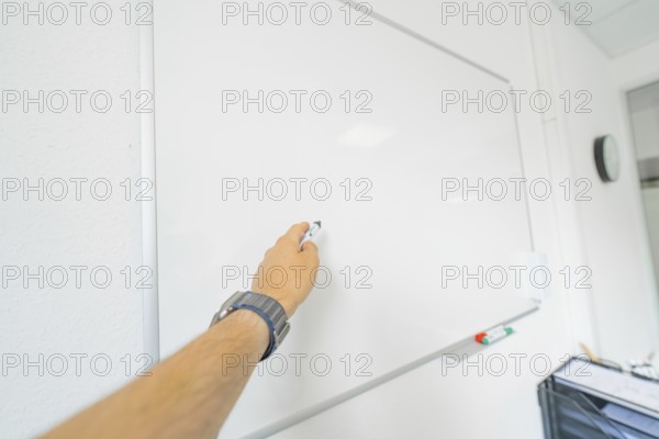 A hand writes with a pen on a white board, Care Connect, vaccination kiosk for refugees, Calw,