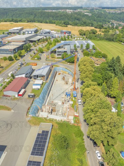 Crane near a construction site with surrounding greenery and buildings, car park construction,