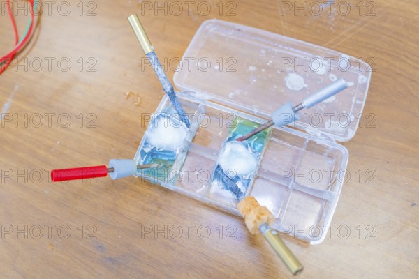 Electrical experiment with wires and a liquid in trays in the laboratory, Battery Research, Nagold,