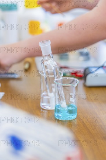 Chemistry experiment with blue liquid beaker on wooden table, Battery Research, Nagold, Germany