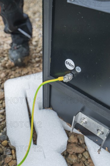 Underground cables are attached to a device and secured to the ground, installation of a charging